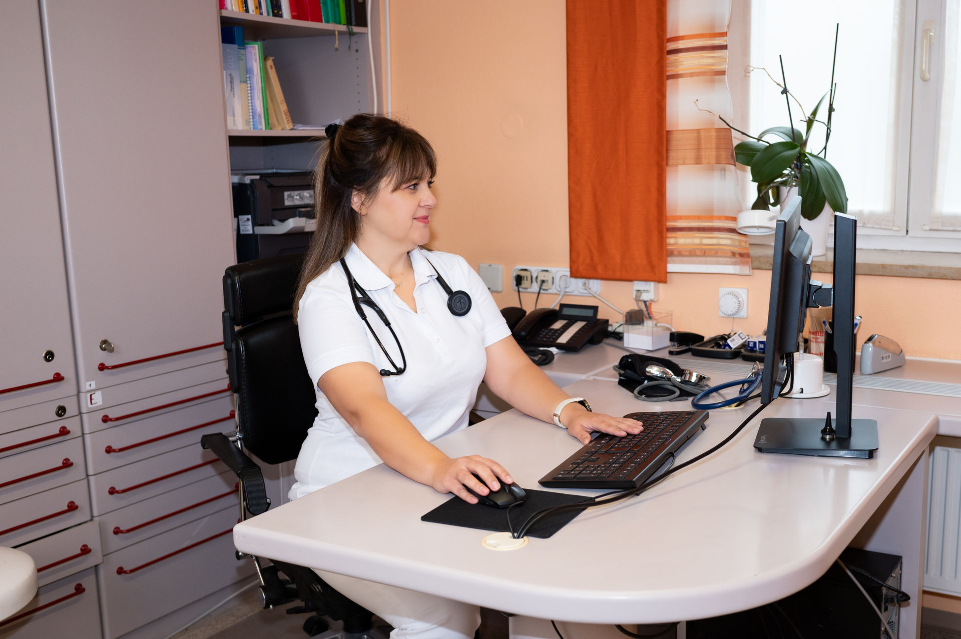 Die Ärztin Emine Aliosman aus Lichtenau sitz am Schreibtisch und arbeitet am Computer.